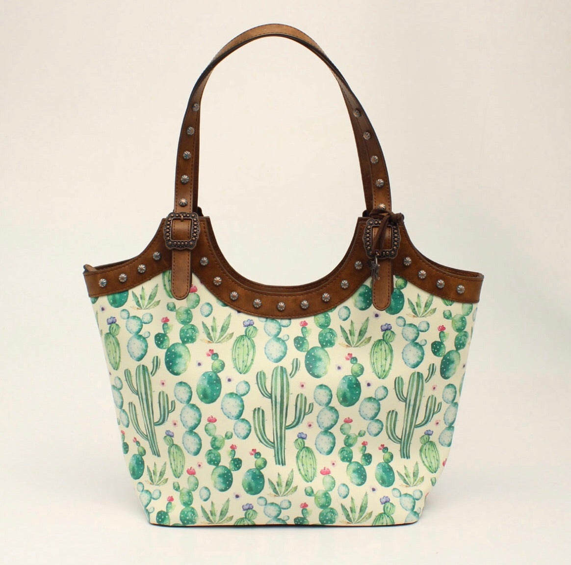 D330001502 Details Cactus Collection Angel Ranch Tote Brown Measures: 16 x 5 x 10 Watercolor Green Cacti with Pink Flower Accents 2 Interior Pockets and Zippered Pocket Concealed Weapon Pocket on Back